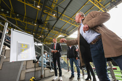 A man raffles off canteen vouchers by throwing darts at a seating plan to determine the winners.