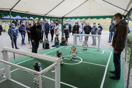 Oktober Besucher*innen schauen Robotern beim Fußballspielen zu