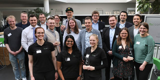 Auf dem Gruppenfoto sind achtzehn Personen und ihre Teampreise zu sehen.