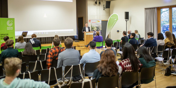 Zuhörer in einem Saal lauschen einer Veranstaltung.