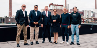 Five men and a woman are standing on a roof.