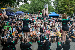 A group of cheerleaders perform in front of a large crowd on campus.