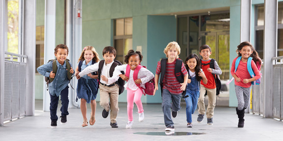 Schulkinder laufen über einen Flur
