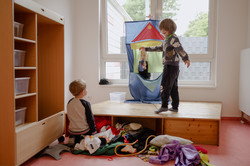Three boys play on a small stage.