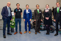 TU-Rektor Prof. Manfred Bayer steht neben Dr. Dennis Freiburg, Prof. Jörn Mosler und Prof. Michael Henke vor einem studentischen Rennwagen.