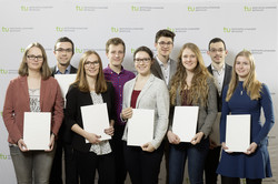 Neun Stipendiatinnen und Stipendiaten halten vor einer TU-Fotowand ihre Urkunden in den Händen.