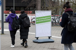 Studierende Drei Studierende laufen über den Campus.