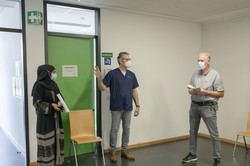 Drei Menschen Eine Frau und zwei Männer stehen beieinander