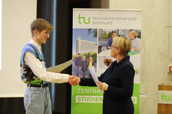 25_SchuelerUni_7757 Feierliche Übergabe erworbener Zertifikate zwischen der Prorektorin Studium Frau Prof. Dr. Wiebke Möhring und einem Teilnehmer während der Eröffnungsveranstaltung der SchülerUni für das Wintersemester 2024/2025.