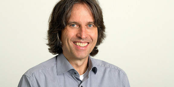 Prof. Schwentick Ein Mann lächelt in die Kamera. Der Hintergrund ist weiß.