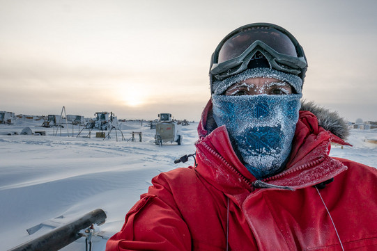 Johannes Werthebach Selfie von einem Mann in roter Jacke, der draußen im Schnee steht und dessen Schal, Wimpern und Augenbrauen von Eis bedeckt sind