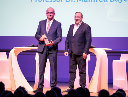 DHV-Gala24_Galaabend Das Bild zeigt Manfred Bayer nebein einem anderen Mann auf der Bühne des Galaabends zur Auszeichnung des Rektors des Jahres