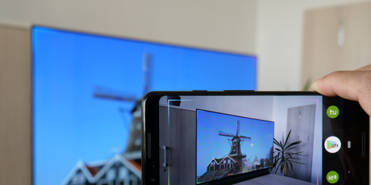 Smartphone überträgt selbes Bild auf TV im Hintergrund