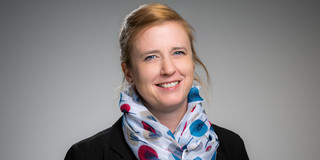 Porträtfoto von Prof. Wiederkehr: Prof. Wiederkehr trägt einen gemusterten Schal und einen schwarzen Blazer. Sie lächelt in die Kamera.