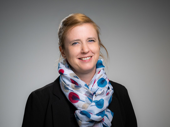Portrait photo of Prof. Wiederkehr: Prof. Wiederkehr wears a patterned scarf and a black blazer. She smiles at the camera.