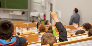 KinderUni Kinder sitzen in einem Hörsaal einer Universität.