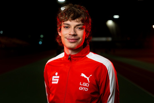 Porträtfoto Jakob Stade: Das Foto zeigt Stade in einer roten Trainingsjacke der LGO. Er lächelt in die Kamera.