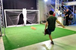 Ein Schüler schießt einen Ball in ein Tor auf einem kleinen Fußballfeld