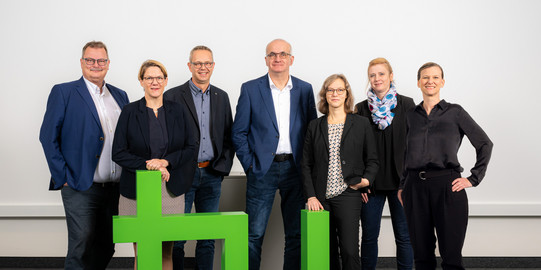 Foto: Das Rektorat der TU Dortmund posiert hinter einem hellgründen TU-Logo. Das Foto zeigt von links nach rechts Prof. Gerhard Schembecker (Prorektor Finanzen), Prof. Wiebke Möhring (Prorektorin Studium), Kanzler Markus Neuhaus, Rektor Prof. Mafred Bayer, Prof. Nele McElvany (Prorektorin Forschung), Prof. Petra Wiederkehr (Prorektorin Diversität) und Prof. Tessa Flatten (Prorektorin Internationales).