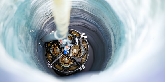 Das Foto zeigt, wie die Glaskugel ins Bohrloch abgelassen wird.