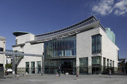 Ein modernes Gebäude mit Glasfassade und geschwungenem Dach.