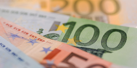 Foto: Mehrere Euro-Banknoten (200, 100, 50) in einer Reihe.