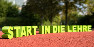 Foto: Die Buchstaben für "Start in die Lehre" stehen auf dem Boden eines Sportplatzes