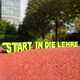 Foto: Die Buchstaben für "Start in die Lehre" stehen auf dem Boden eines Sportplatzes