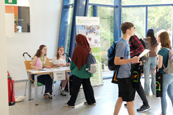Ausgabe der Mappen am ersten Tag der SchnupperUni Teilnehmende werden empfangen und bekommen eine Mappe und den SchnupperUni-Stundenplan.