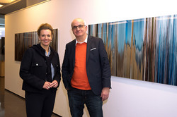 Ina Brandes and Manfred Bayer stand in front of pictures from the exhibition