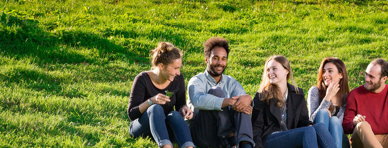 Alumni sit together on the grass