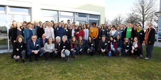 Gruppenfoto auf einer Wiese vor einem Gebäude