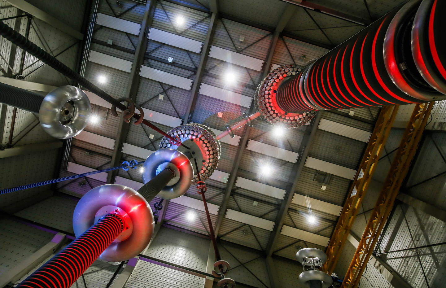 Foto aus dem Inneren des HGÜ-Testzentrums, mit rot und blau beleuchteten technischen Elementen