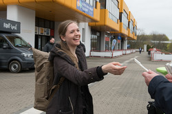Ausgabe von Kulis Eine Frau hält einen Kuli in der Hand und lächelt.