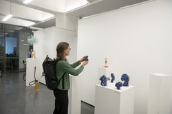 Ausstellung „Rundgang Kunst“ Eine Frau im grünen Pullover fotografiert mit dem Handy ein Kunstobjekt einer Kunstausstellung.