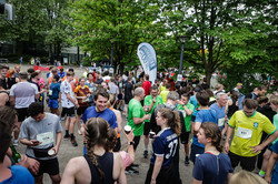 Viele Leute in Sportklamotten stehen beieinander und trinken Wasser aus Pappbechern