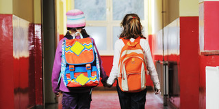 The photo shows two little girls at school