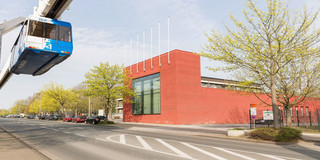 The International Meeting Center on Campus North. The H-Bahn is driving past.