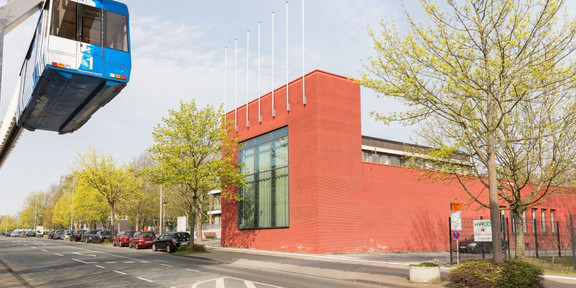 Internationales Begegnungszentrum Das rot verklinkerte Internationale Begegnungszentrum auf dem Campus Nord. Im Vordergrund fährt die H-Bahn.