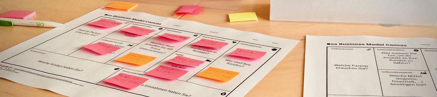 Papers and post-its about business models on a table