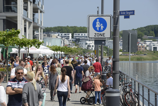 Fußgänger Zone mit vielen Menschen, Restaurants und entlang am Wasser.