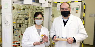 Eine Frau und ein Mann stehen in Schutzkleidung in einem Labor