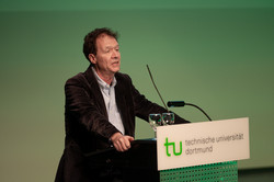 Ein Herr im Anzug steht an einem Rednerpult mit der Aufschrift "TU Dortmund".
