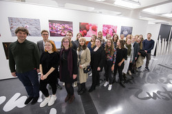 Eine Gruppe von Studierenden steht vor den Bildern der AUsstellung