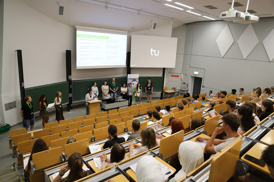 Teilnehmende sitzen im Hörsaal und schauen auf die Vortragenden der SchnupperUni