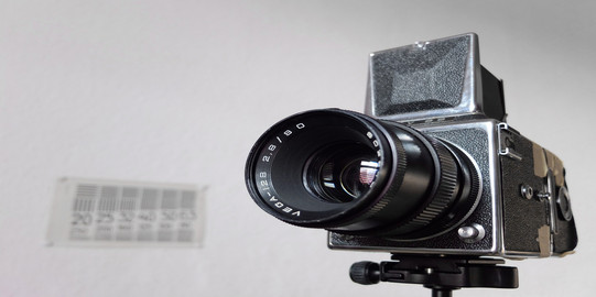 older model of a video camera in front of a wall with a calendar