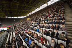 Many people sit in the stands of a stadium.