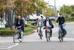 Oktober Vier Personen fahren mit Fahrrädern auf einer Straße.