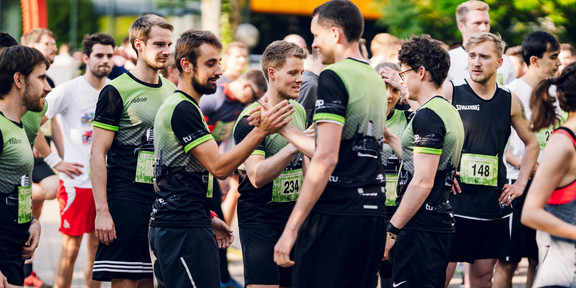 Campuslauf Mehrere Menschen in Sportkleidung stehen zusammen.