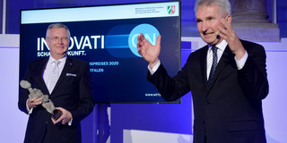 Innovationspreis NRW Prof. ten Hompel und Wirtschaftsminister Andreas Pinkwart stehen nebeneinander auf einem Podium.